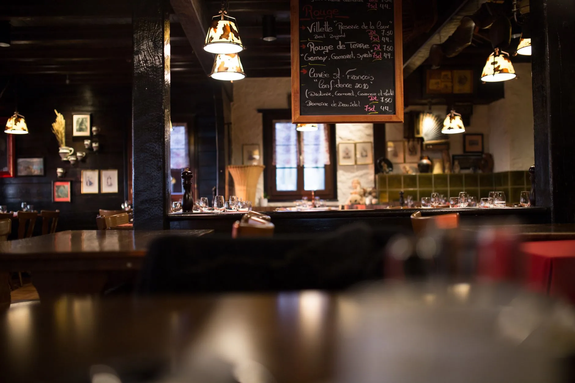 Warm and inviting interior design of a vintage-style restaurant with wooden furnishings and dim lighting.