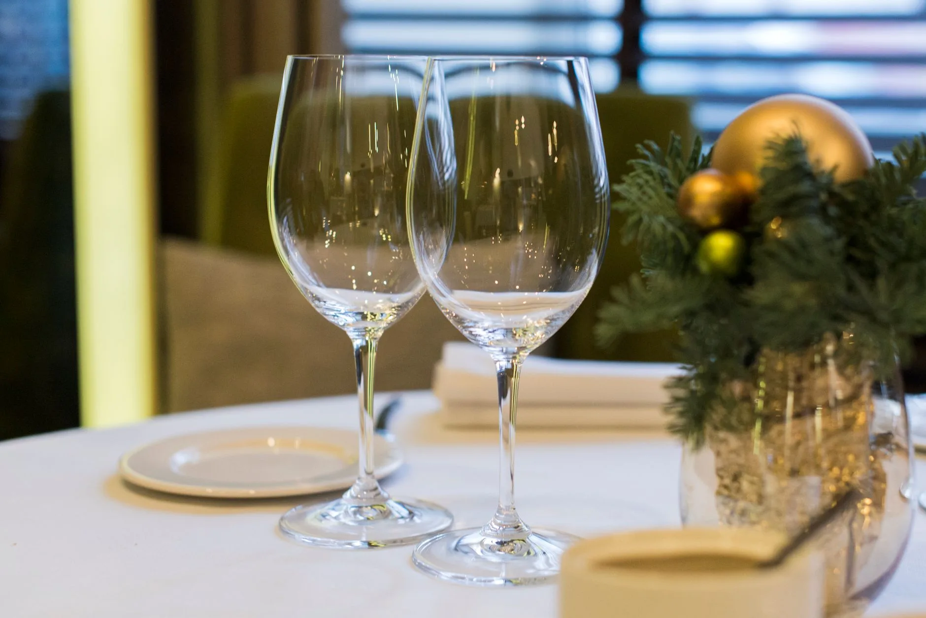 Sophisticated dining table setup with wine glasses and festive Christmas decorations offering elegance and warmth.